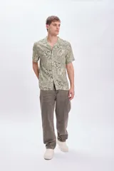 Camisa casual de viscosa con estampado en tonos verde y beige, de manga corta y cuello americano.