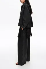 Chaqueta corta de corte línea A confeccionada en mezcla de algodón color negro. Presenta cuello camisero, mangas largas con botones, bolsillos delanteros tipo plastrón y canesú con maxi pliegue en la espalda.