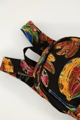 Mochila negra con estampado colorido de bananas, compartimento principal amplio, bolsillo frontal con cierre y correas ajustables.