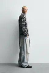 Cárdigan de punto con diseño de rayas horizontales en tonos grises y negros. Presenta un corte relajado, cuello en pico, cierre frontal con botones y acabados en rib en puños y bajo.