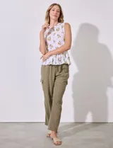 Blusa sin mangas de algodón estampado con flores amarillas, cuello a la base, escote en V y entrelazado. Terminación de ruedo con frunce.