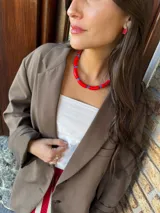 Collar corto tipo gargantilla compuesto por cuentas tubulares acrílicas rojas y cuentas cilíndricas pequeñas de cristal checo azul.