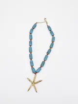 Collar de diseño marinero con cuentas tubulares de efecto marmolado en tonos celestes, intercaladas con cuentas rojas y doradas, y un dije colgante en forma de estrella de mar dorada.