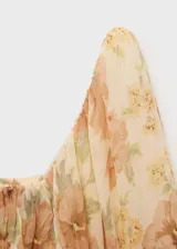 Blusa de gasa color crema con estampado de flores en tonos naranja y verde, escote cuadrado con detalle fruncido, mangas largas abullonadas y espalda abierta.