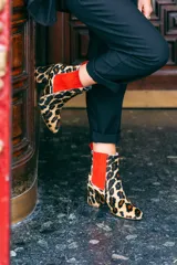 Botines de cuero con estampado animal print, con elástico lateral rojo y taco cuadrado.