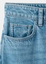 Pantalón de mezclilla de tiro medio con diseño acampanado estilo flare, trabillas para cinturón y clásico diseño de cinco bolsillos con cierre frontal de botón y cremallera.