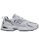 Championes New Balance modelo 530 de estilo retro para running, confeccionados en malla blanca con superposiciones plateadas y azul marino. Cuentan con amortiguación ABZORB en la suela y el característico logotipo "N" en los laterales.