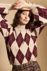 Polera de tejido de punto con diseño de rombos en color bordó y beige, cuello alto y mangas largas con puños ajustados.