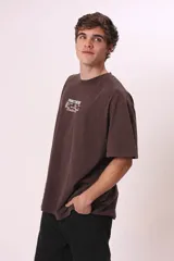 Camiseta de manga corta, color gris oscuro con efecto lavado, corte oversize y cuello redondo. Presenta un pequeño estampado en el pecho con el texto "CREW MEMBER" en blanco.