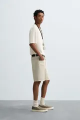 Polo de punto de corte regular fit, confeccionado en una mezcla de algodón y lyocell. Presenta cuello de solapa con cierre frontal de botones, manga corta y acabados en rib en puños y bajo.