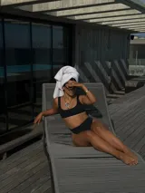 Top de bikini negro de corte recto, con tirantes anchos y diseño minimalista.