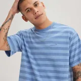 Remera Levi's de manga corta con diseño de rayas horizontales en tonos de azul y el logo de la marca bordado en el pecho.