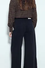 Jean de corte wide leg y tiro medio, confeccionado en denim negro con costuras reforzadas y diseño de pierna ancha.