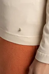 Remera color crema de algodón y elastano, de corte ajustado y mangas largas, con cuello barco.