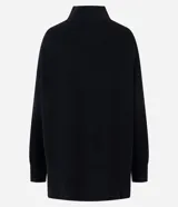Suéter de punto de corte oversize y largo alargado, con cuello alto, mangas largas y aberturas laterales sutiles. Presenta puños y ruedo con acabado acanalado.