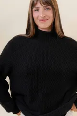 Polera de tejido de punto con textura marcada, cuello alto y diseño oversize con hombros caídos y terminaciones acanaladas.