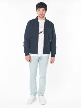 Campera bomber azul marino de poliéster con cierre frontal, puños y dobladillo de punto canalé, bolsillos exteriores con cierre y logo CK bordado en el pecho.