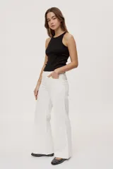 Pantalón de tiro medio y corte wide leg color beige, con diseño clásico de cinco bolsillos, presillas para cinto y cierre frontal con botón y cremallera.