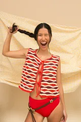 Chaleco tejido a mano en crochet con hilado 100% algodón, con diseño de ondas horizontales en colores azul, rojo y verde. Tiene tiras para atar en el frente.