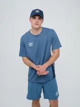 Remera deportiva Umbro modelo Vant, de color negro con paneles laterales grises y cuello redondo, diseñada para hombre.