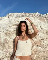 Collar artesanal con dije central de metal con textura orgánica irregular que evoca una ostra. El dije está montado sobre un cordón de algodón natural, permitiendo un uso versátil y regulable.