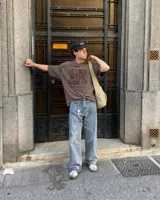 Remera oversize color beige con efecto acid wash y estampa frontal en marrón con la frase "Killing In The Name Of".