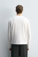 Camiseta de manga larga con corte relajado, confeccionada en algodón con acabado mercerizado y cuello redondo acabado en rib.