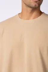 Remera de corte oversize color negro, con cuello redondo y detalle de costura en forma de X en el frente.