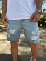 Bermuda de jean de corte ajustado con roturas y flecos en la parte frontal.