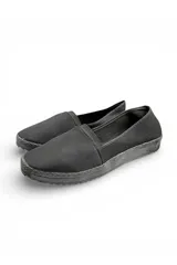 Zapatillas tipo pancha de lona negra, de diseño clásico y suela de goma flexible.
