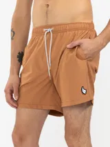 Short de baño azul marino con bordado de enredadera en la pierna izquierda. Tiene cintura elástica con cordón regulable, bolsillos laterales y trasero con cierre, y suspensor de malla fina hipoalergénico.