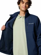 Campera softshell Columbia modelo Ascender, color azul marino, con cuello alto, cierre frontal completo, bolsillos laterales y en el pecho con cierre, y puños ajustables.