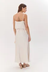 Falda larga color beige confeccionada en satén, de corte recto y cintura elastizada.