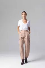 Pantalón gris de tiro alto con pinzas, bolsillos cargo laterales y ruedo ajustable con botones.