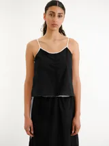 Vestido largo negro de tirantes finos blancos, corte recto y diseño minimalista.