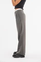 Pantalón de vestir color beige, de corte recto y tiro alto, con pretina blanca.