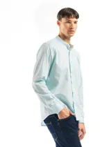 Camisa de manga larga color gris claro, con cuello mao, cierre frontal con botones y bolsillo en el pecho.