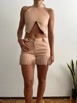 Short color nude de cuero sintético con flecos en el ruedo.