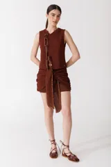 Minifalda marrón tejida en punto firme, con lazos laterales que se anudan al frente.