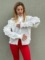 Camisa blanca de cuello mao con volados, mangas largas con puños ajustados y corte clásico.