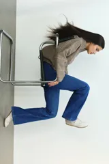 Pantalón jean de denim azul elastizado, de tiro bajo y corte ajustado con botamanga acampanada. Presenta diseño clásico de cinco bolsillos y cierre frontal con botón y cremallera.