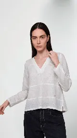 Remera de manga larga confeccionada en una combinación de lino y algodón. Presenta escote en V, diseño con cortes frontales y detalle de logo bordado. Posee un calce cómodo con aberturas laterales en el ruedo.