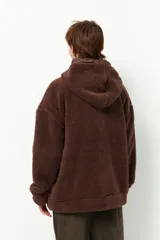 Campera tipo canguro teddy negra con capucha y cierre. El forro es de felpa color verde militar.