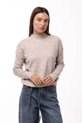 Sweater de tejido de punto color verde oliva, con textura de pequeños relieves circulares, cuello redondo y mangas largas con puños acanalados.