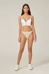 Tanga de encaje blanco con detalles en tul y elástico fino en la cintura.
