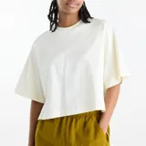 Remera de algodón blanca de corte amplio y suelto, con cuello redondo, mangas raglán cortas, aberturas laterales y logo bordado en el mismo tono.