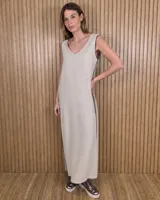 Vestido largo negro de corte holgado, sin mangas y con escote redondo. Presenta detalles de ribetes contrastantes en color beige en los laterales y sisas.