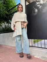 Camisa de corte holgado con estampado de cuadros escoceses en tonos beige y marrón. Presenta cuello clásico, cierre frontal con botones y mangas largas.