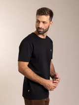 Remera básica de manga corta y cuello redondo, color blanco, con pequeño logo bordado en el pecho.