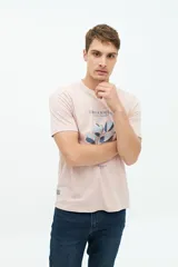 Remera de manga corta color rosado, con estampado frontal de hojas en tonos azules y texto "Organiquis Les Formes" y "Bisfield Est. 1971".